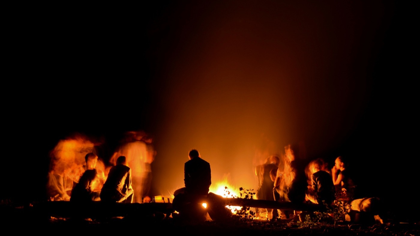 People gathered around a campfire at nighttime